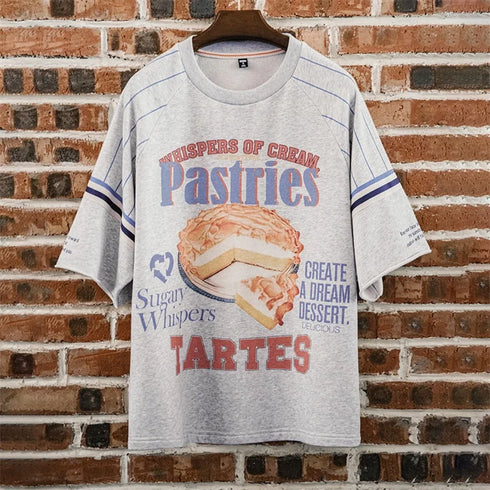 Gray t-shirt with dessert-themed design on a brick wall background